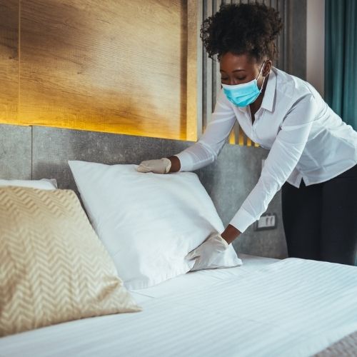 housekeeper making a bed perfectly in San Antonio, TX
